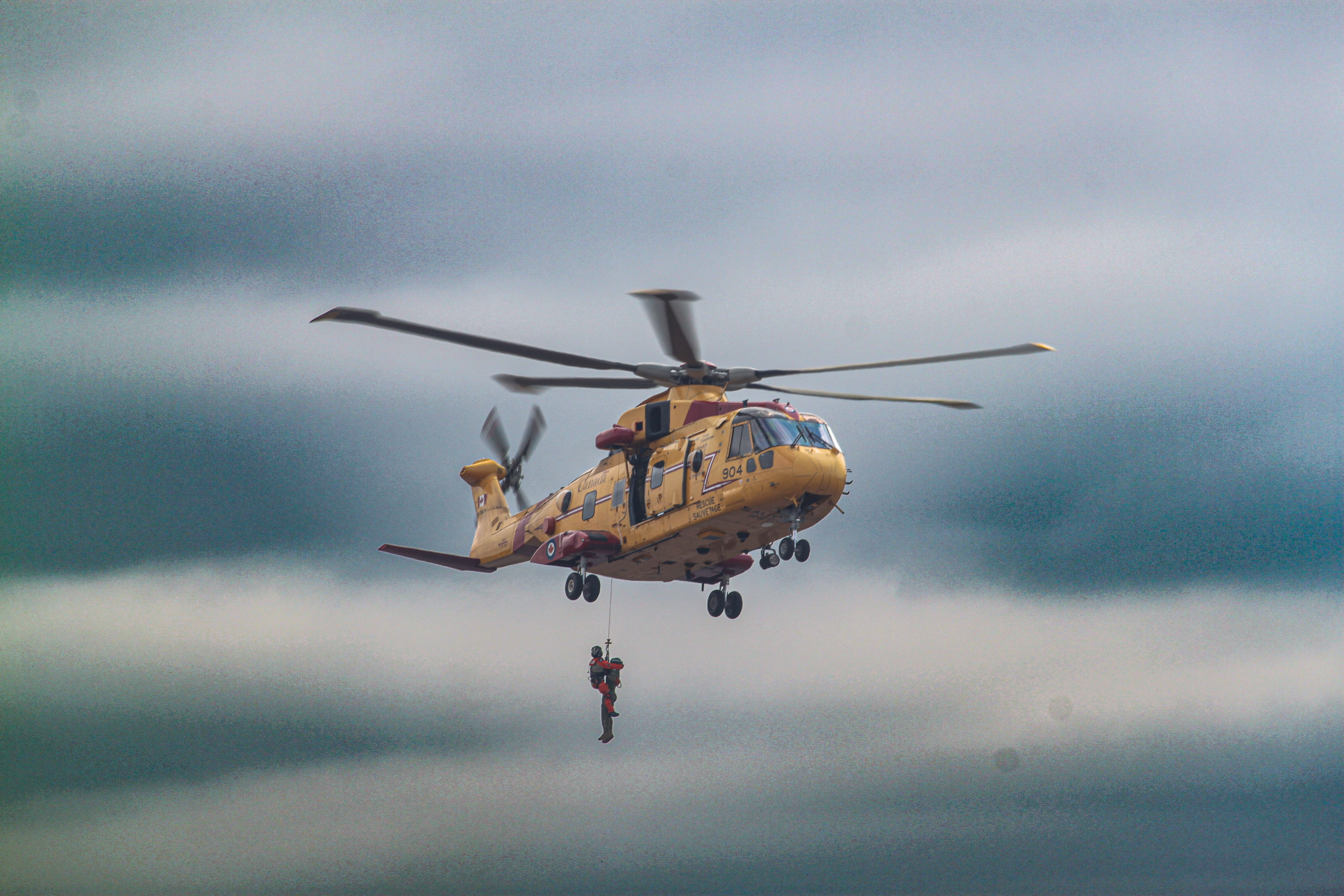 Rescue helicopter mid-hoist